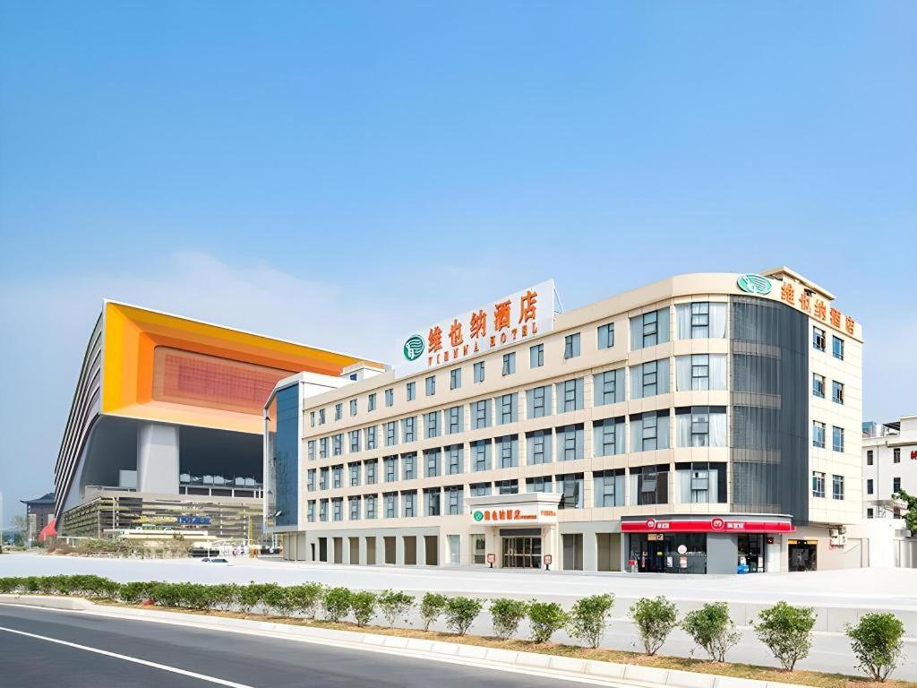a large building on the side of a road at Vienna Hotel Guangzhou Huadu Financial Center Sunac Amusement Park in Huadu