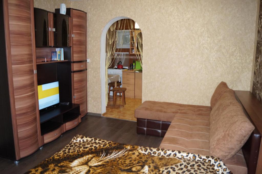a living room with a couch and a flat screen tv at Apartments Colonnade in Kislovodsk