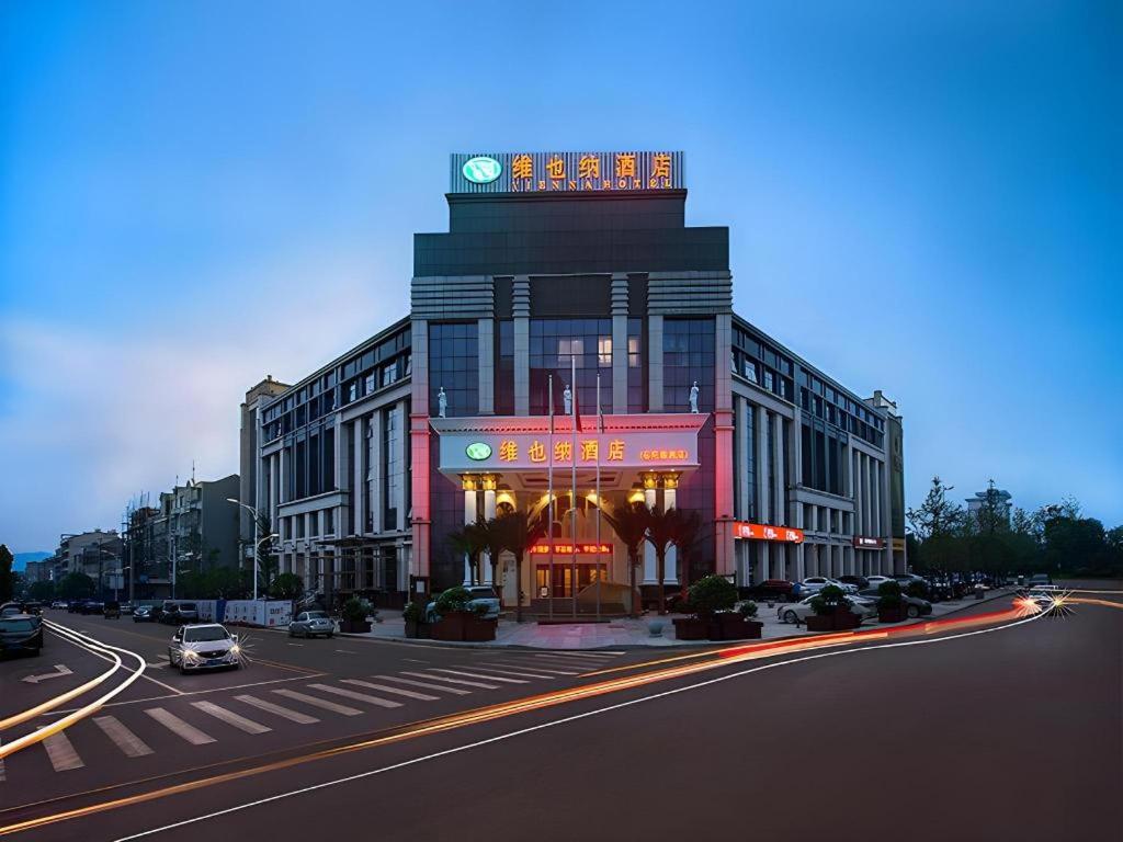 un grand bâtiment avec une tour d'horloge au sommet dans l'établissement Vienna Hotel Hunan Yueyang Linxiang, à Yueyang
