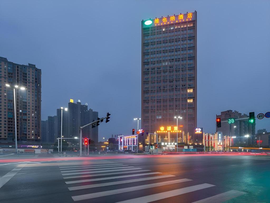 une rue de ville vide la nuit avec de grands bâtiments dans l'établissement Vienna Hotel Nanchang New Grand Hongcheng Market Xianghu 1st Hospital, à Nanchang