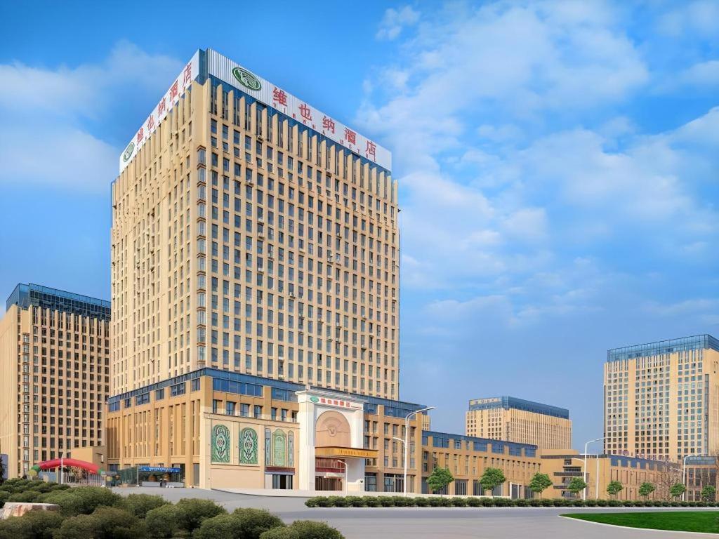 a tall building with a sign on top of it at Vienna Hotel Anhui Fuyang Funan Bailing Apartment in Funan