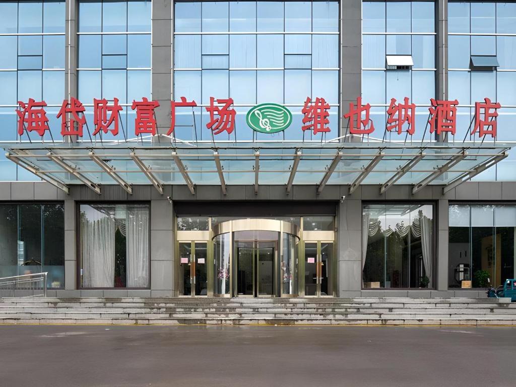a building with a sign on top of it at Vienna Hotel Shandong Qingzhou Ancient City in Yanghe