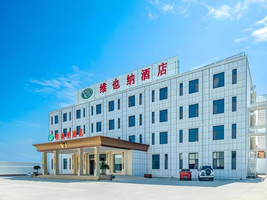 a hotel with a sign on top of it at Vienna Hotel Shandong Qingdao Jiaodong International Airport Hai'er Avenue in Qingdao