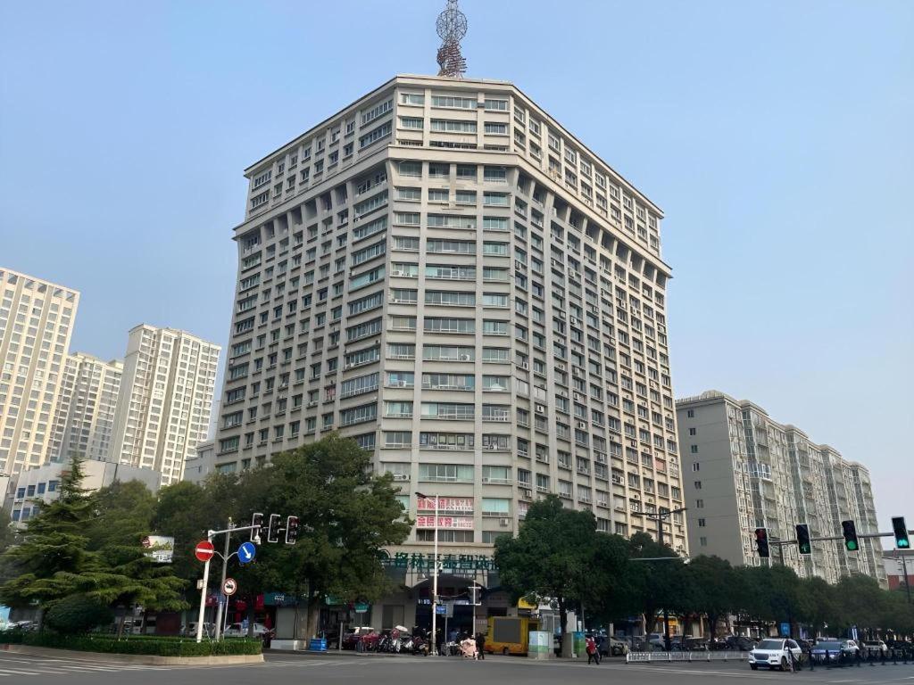 a tall building with a tower on top of it at Green Tree Inn Luoyang Fenghuang Mansion Mudan Square Metro Station in Luoyang