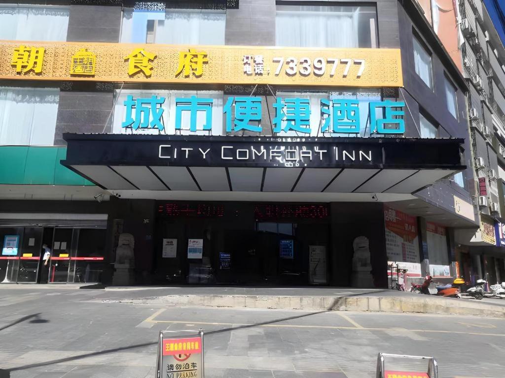 une auberge au coin de la ville avec des panneaux bleus sur un bâtiment dans l'établissement City Comfort Inn Changning Wangchao, à Changning