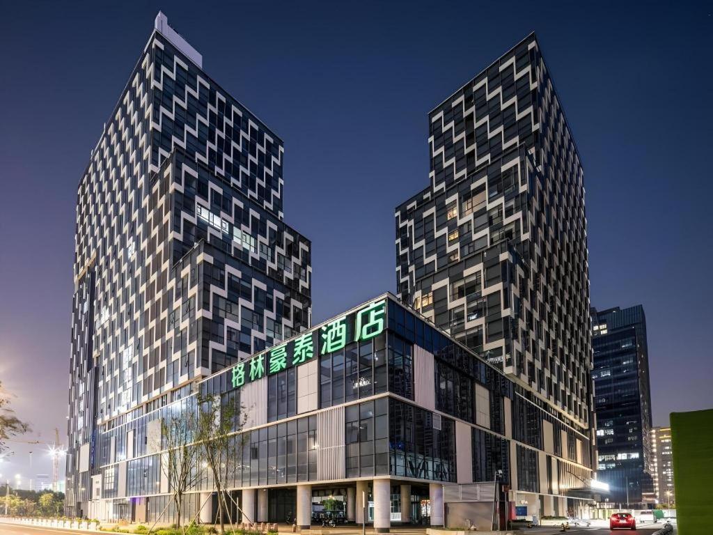 zwei hohe Gebäude mit einem Schild davor in der Unterkunft Green Tree Inn Suzhou Wujiang East Tai Lake Tourism Resorts in Suzhou