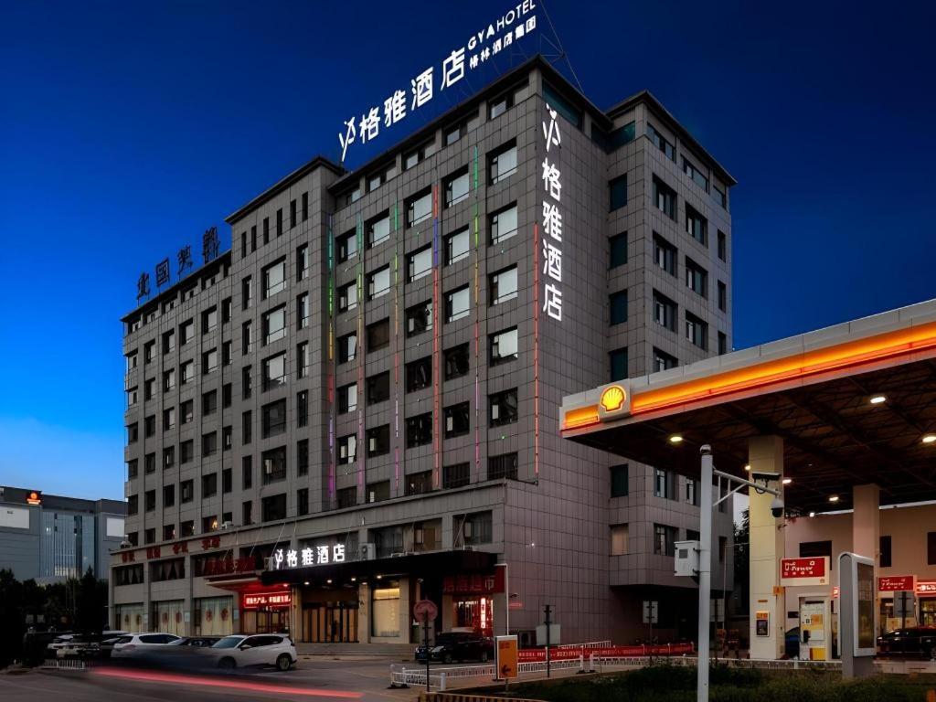 un bâtiment avec une enseigne au sommet dans l'établissement GYA Hotel Taiyuan Zonggai Zone Ancient County Chengnan Station, à Taiyuan