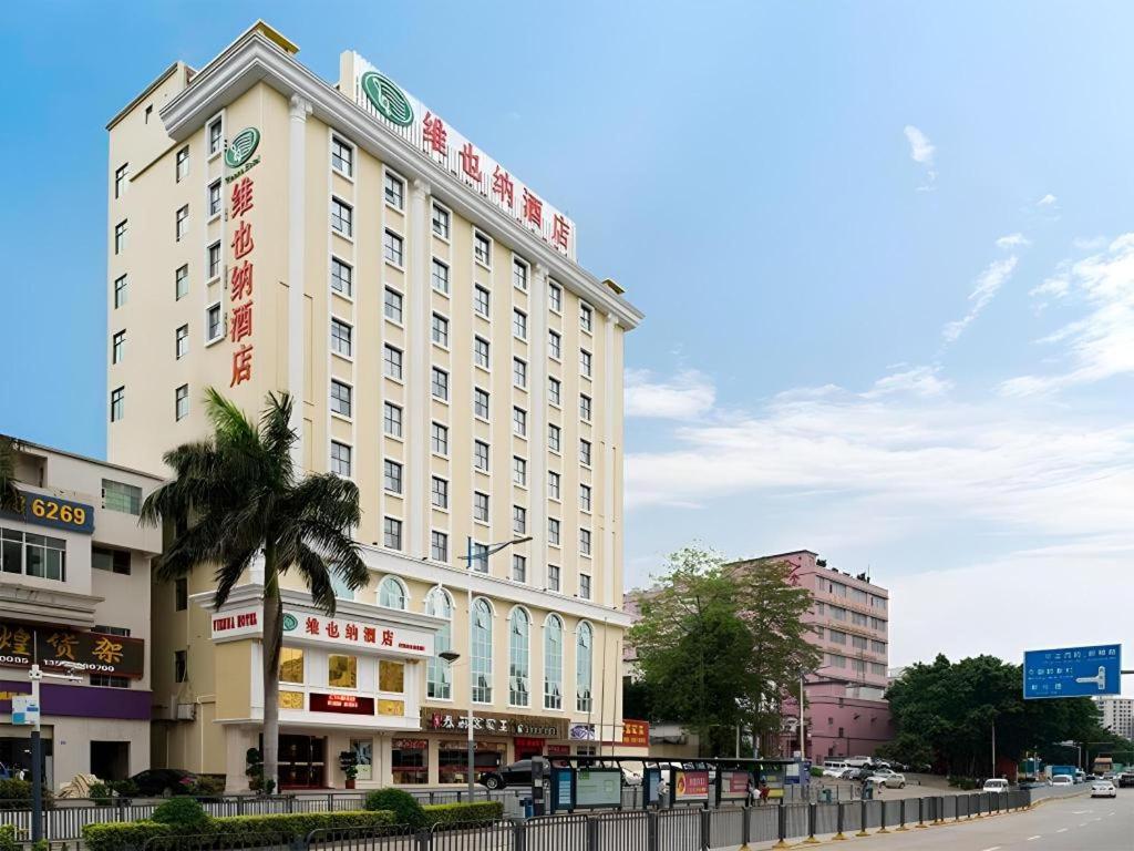 ein großes weißes Gebäude am Straßenrand in der Unterkunft Vienna Hotel Shenzhen Guanlan Shanshuitianyuan Xintian in Tiantangwei