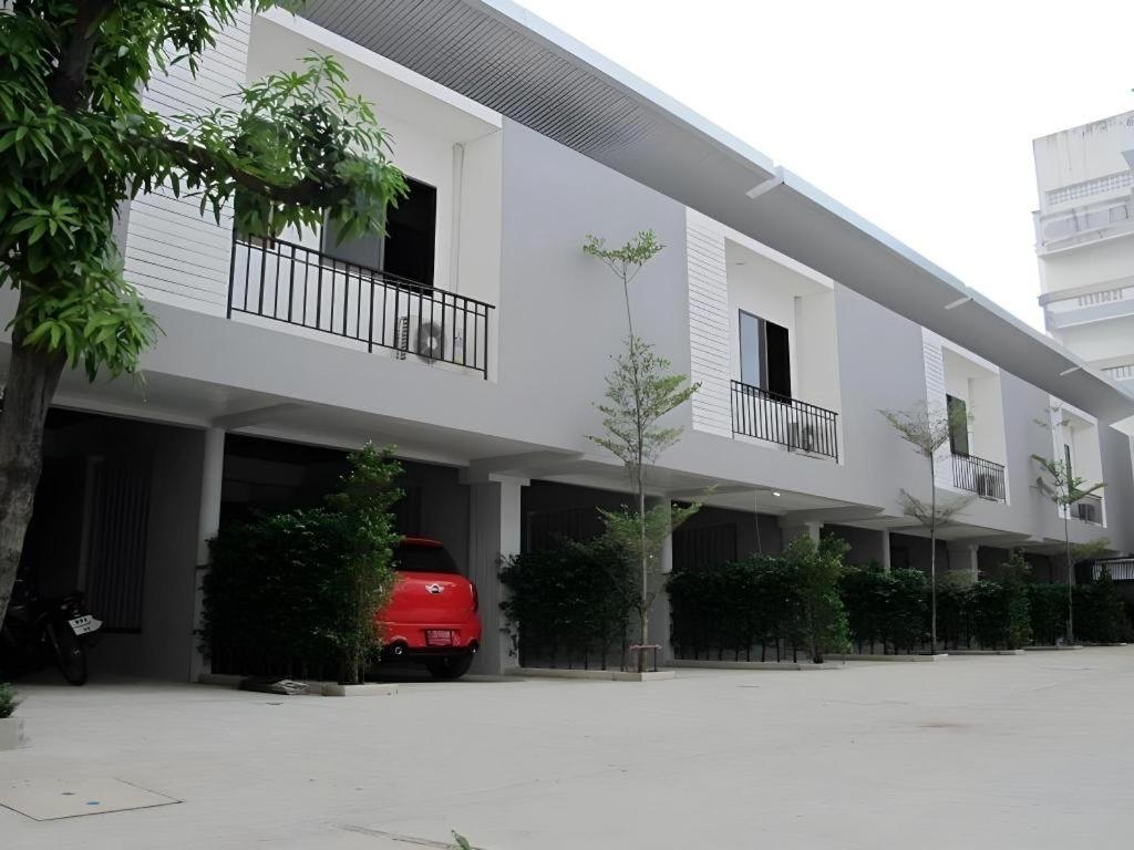 a red car parked in front of a building at 189 Resort in Ban Khlong Samrong