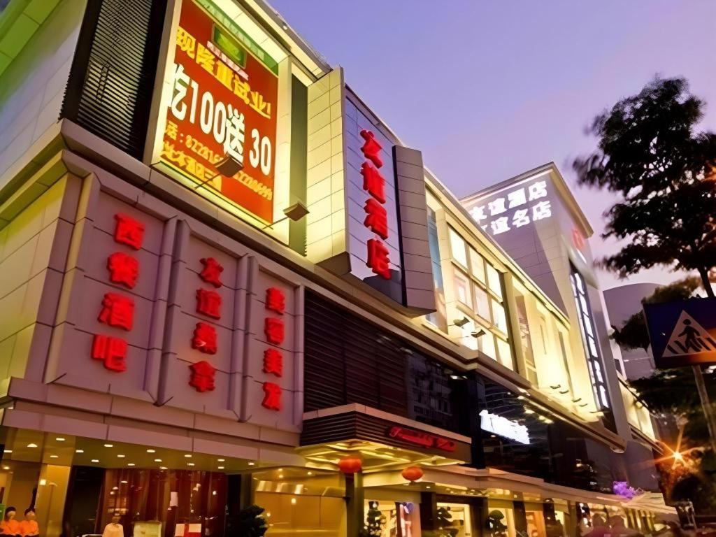 a store with neon signs on the side of it at Friendship Hotel in Shenzhen