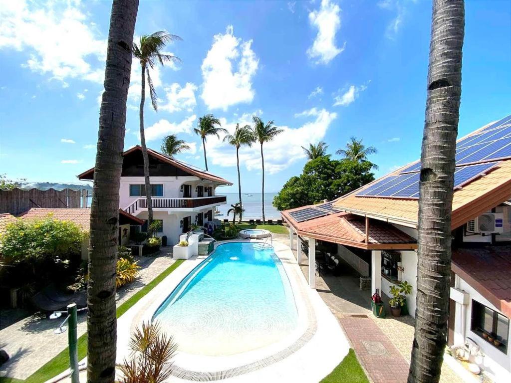 an image of a house with a swimming pool and palm trees at Coral Beach Club in Matabungkay