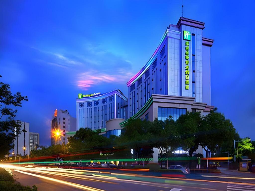 a large building with a sign on it at night at Holiday Inn Express Nantong Downtown By IHG in Nantong
