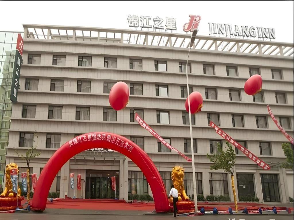 a building with a red arch in front of it at Jinjiang Inn Dalian Jinzhou Hengda Garden in Jinzhou
