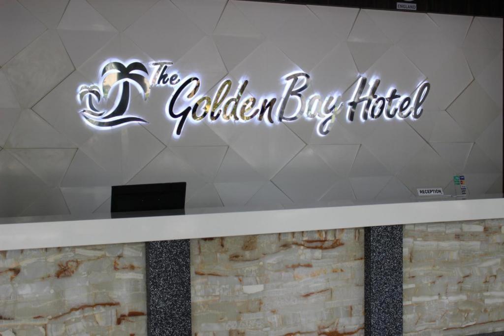 a sign for the golden jug hotel on a wall at The Golden Bay Hotel Batam in Nagoya