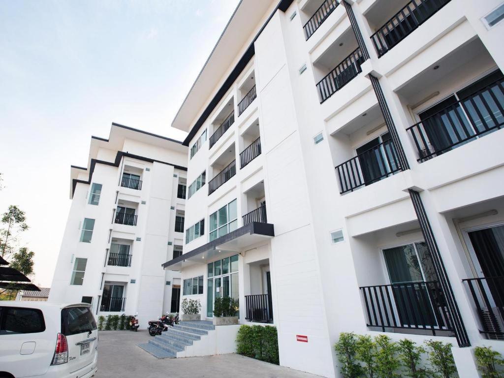 a white building with a car parked in front of it at B2 Korat Boutique and Budget Hotel in Ban Pra Dok