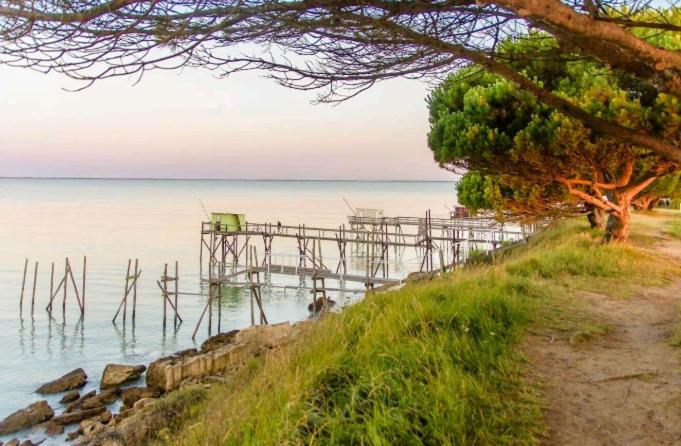 a dock on the water with a pier on the shore at Maison spacieuse proche de la Mer in Échillais