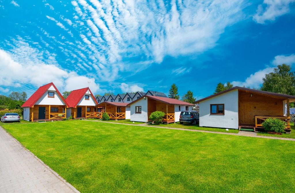 a row of houses with a green lawn at Uroczy Zakatek in Chłopy