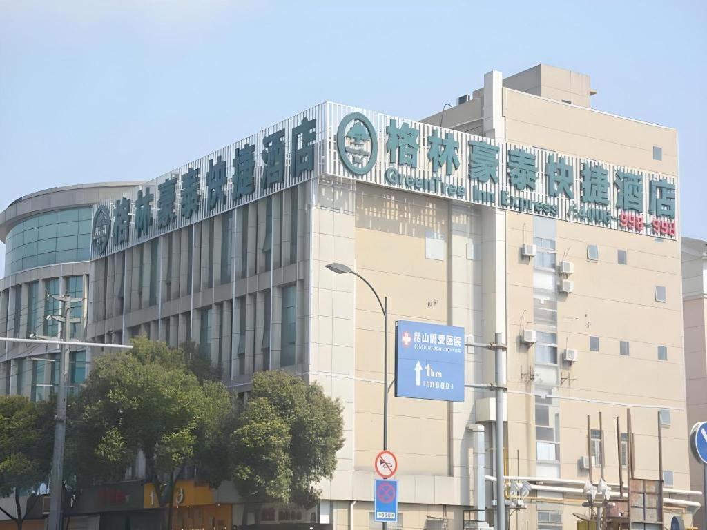 a building with a sign on the top of it at GreenTree Inn Jiangsu Suzhou Kunshan Beimen Road Express Hotel in Suzhou