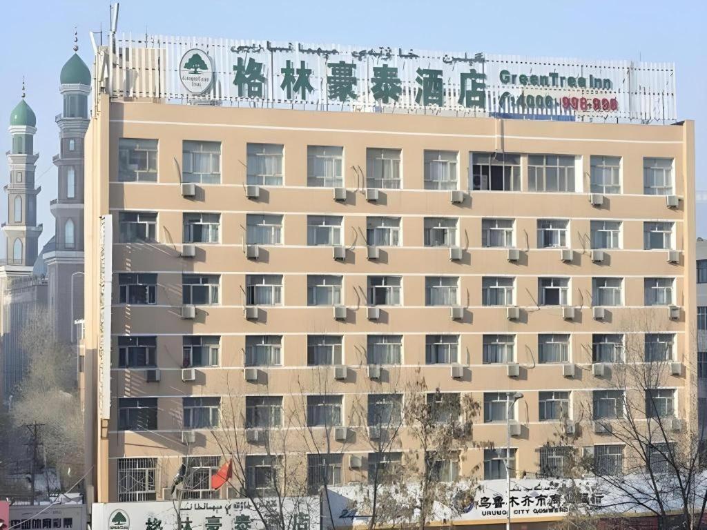 a building with a sign on top of it at GreenTree Inn Urumqi South Xinhua Road Hotel in Ürümqi