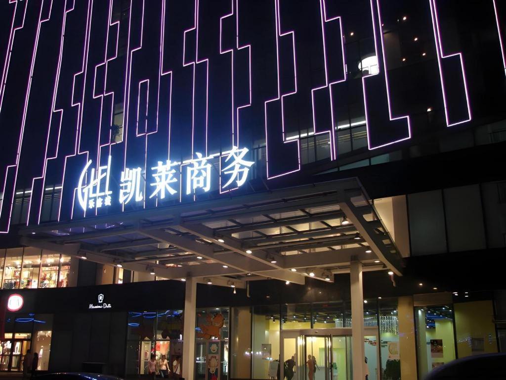 un bâtiment avec un panneau éclairé la nuit dans l'établissement Gtel Rock City Qingdao Hotel, à Laoshan