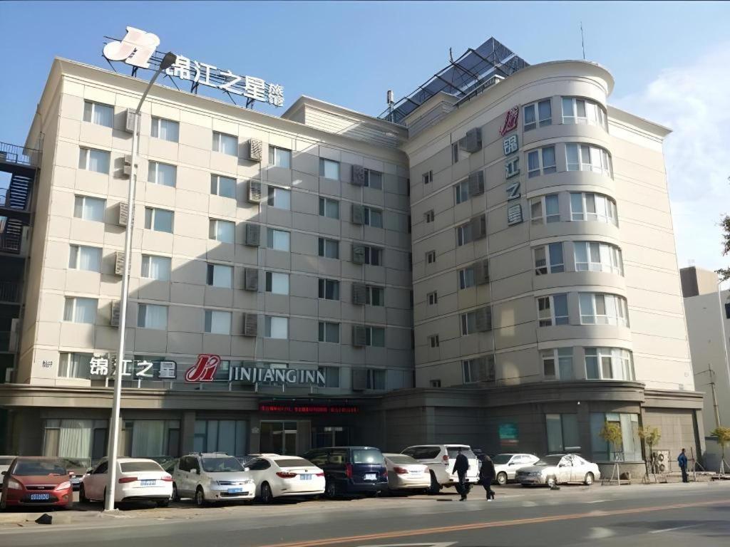 a large building with cars parked in front of it at Jinjiang Inn - Xishan Road in Dalian
