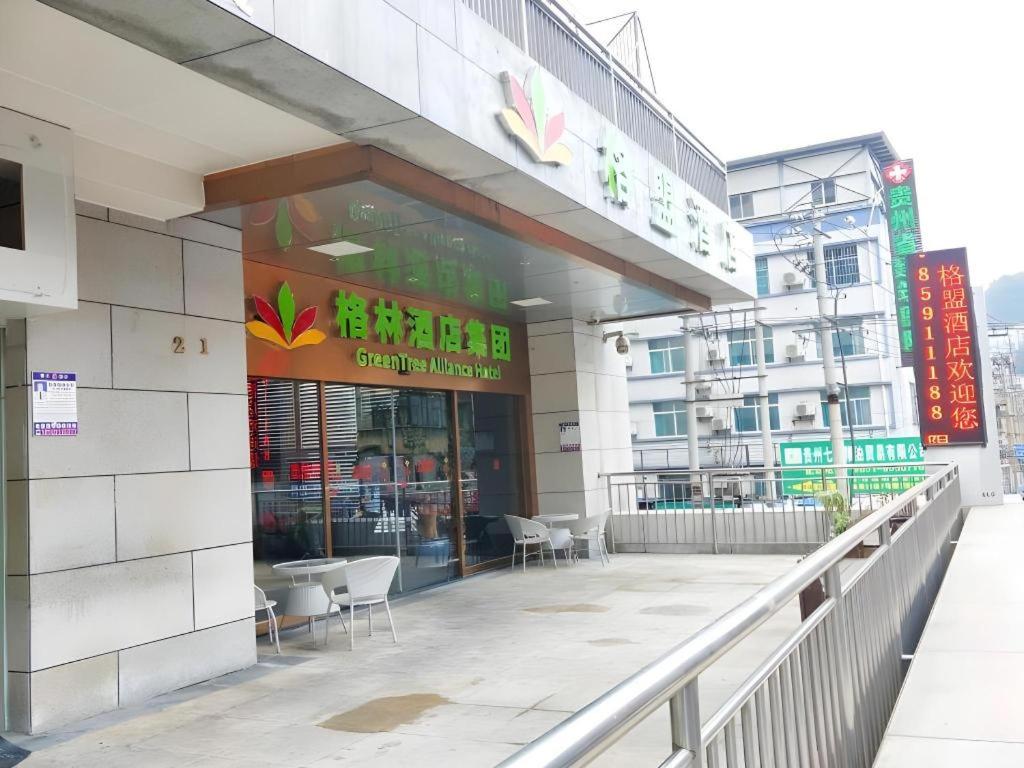 a building with a restaurant with chairs in front of it at GreenTree Alliance Hotel Guiyang Huaguo Community Central Business Zone in Guiyang