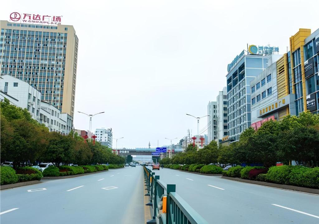 une rue vide dans une ville avec de grands immeubles dans l'établissement City Comfort Inn Xianning South Station Wanda, à Wenquanzhen
