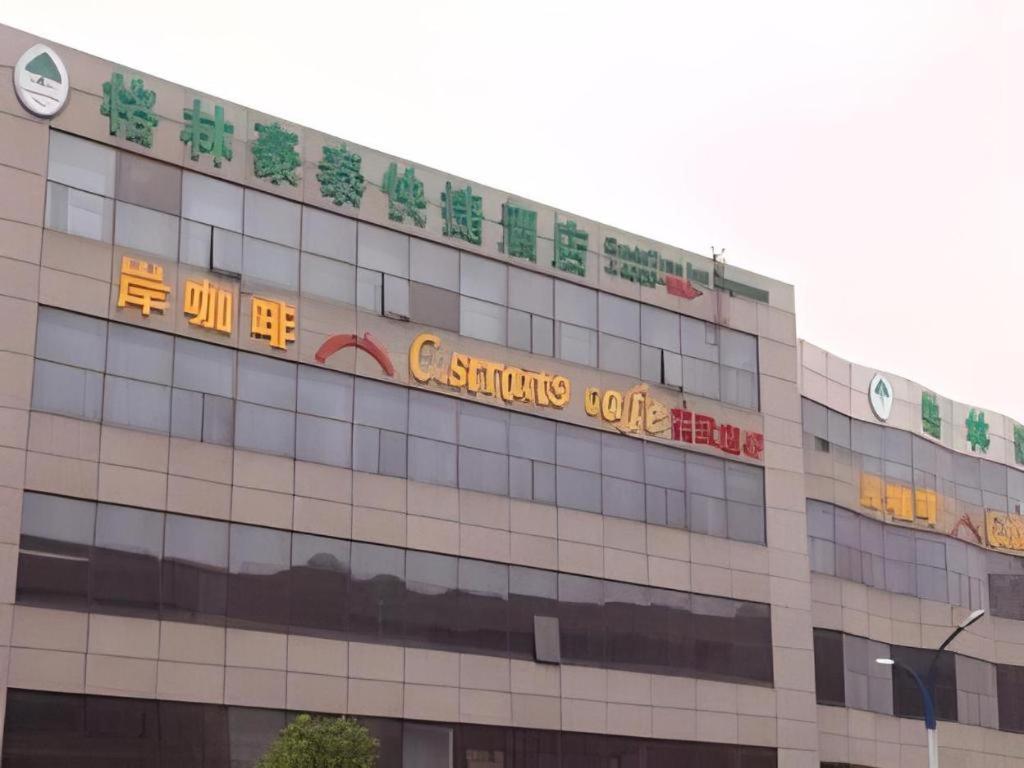 a building with a sign on the side of it at GreenTree Inn xinghua Middle Yingwu Road Express Hotel in Xinghua