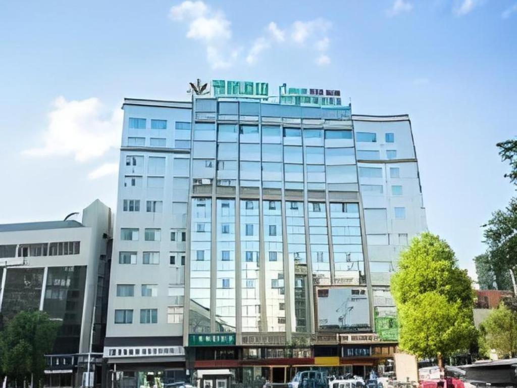 a tall building with a sign on top of it at GreenTree Alliance Hotel Yongzhou Lingling Zhong Road in Guzhuting