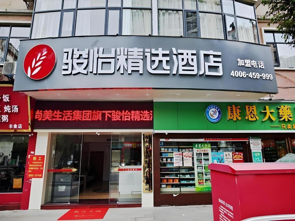 ein Geschäft mit einem Schild an der Vorderseite in der Unterkunft Jun Hotel Guangxi Wuzhou Changzhou District Fengye Garden in Wuzhou