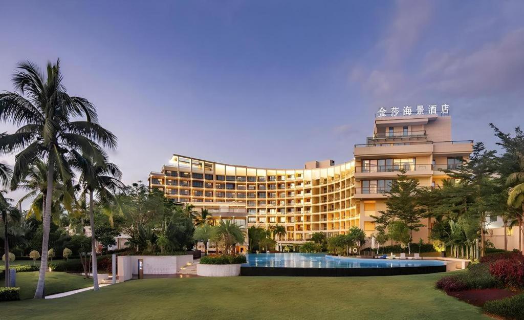 a large building with a swimming pool in front of it at Jinsha Seaview Hotel Sanya in Sanya