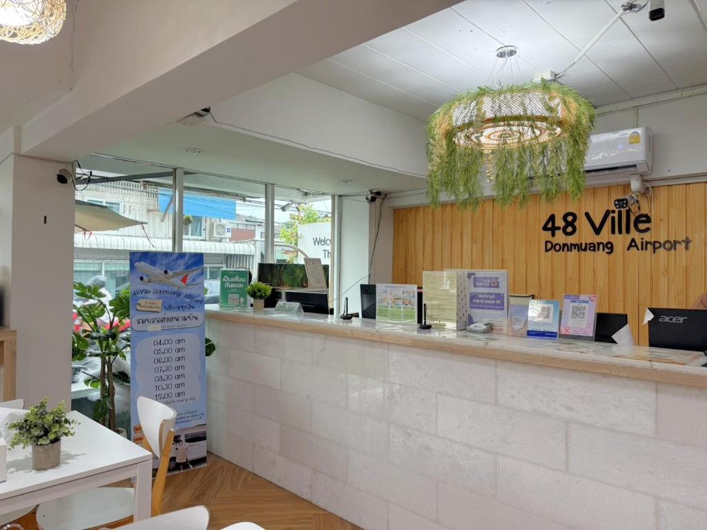 Reception counter with the 48 Ville Donmuang Airport sign.