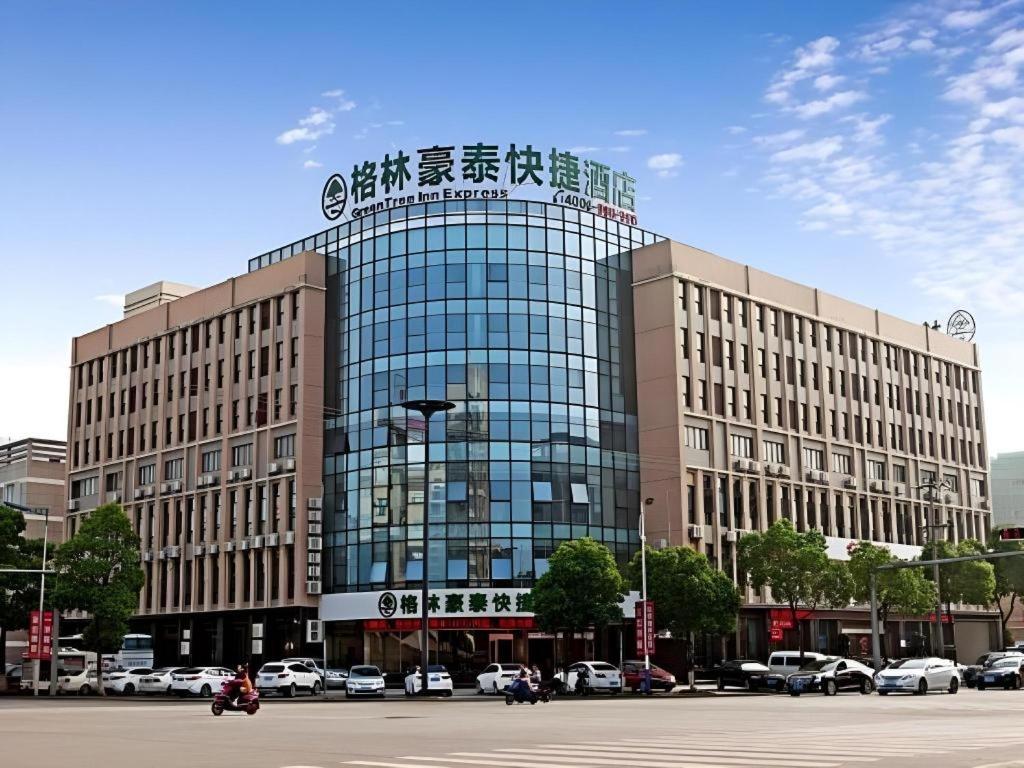 a large building with a sign on top of it at GreenTree Inn HuZhou AnJi YingBin Avenue Express Hotel in Huzhou