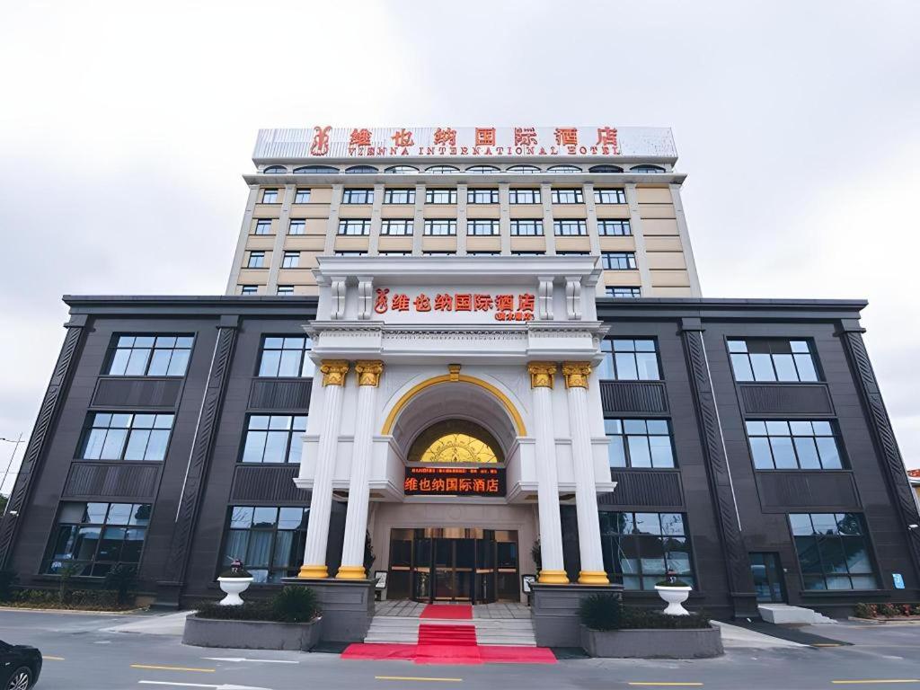 a large building with an arch in front of it at Vienna International Hotel Shanghai Dishui Lake Lingang Wanda in Shanghai