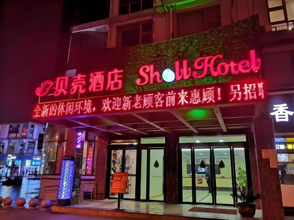 un edificio con letreros de neón en la parte delantera en Shell Suzhou Exhibition Center Huning Chengtie Zone Station Jinfeng Square, en Suzhou