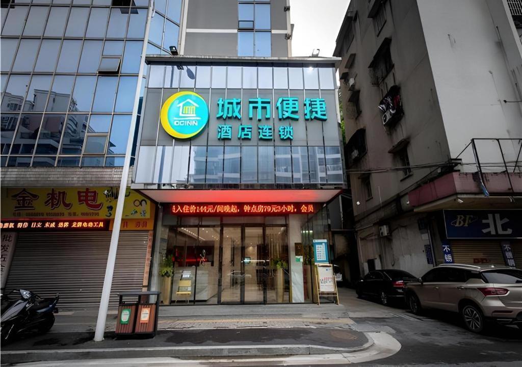 een gebouw met een bord aan de kant van een straat bij City Comfort Inn Jiangmen Xinhui Xiangshan Park in Xinhui