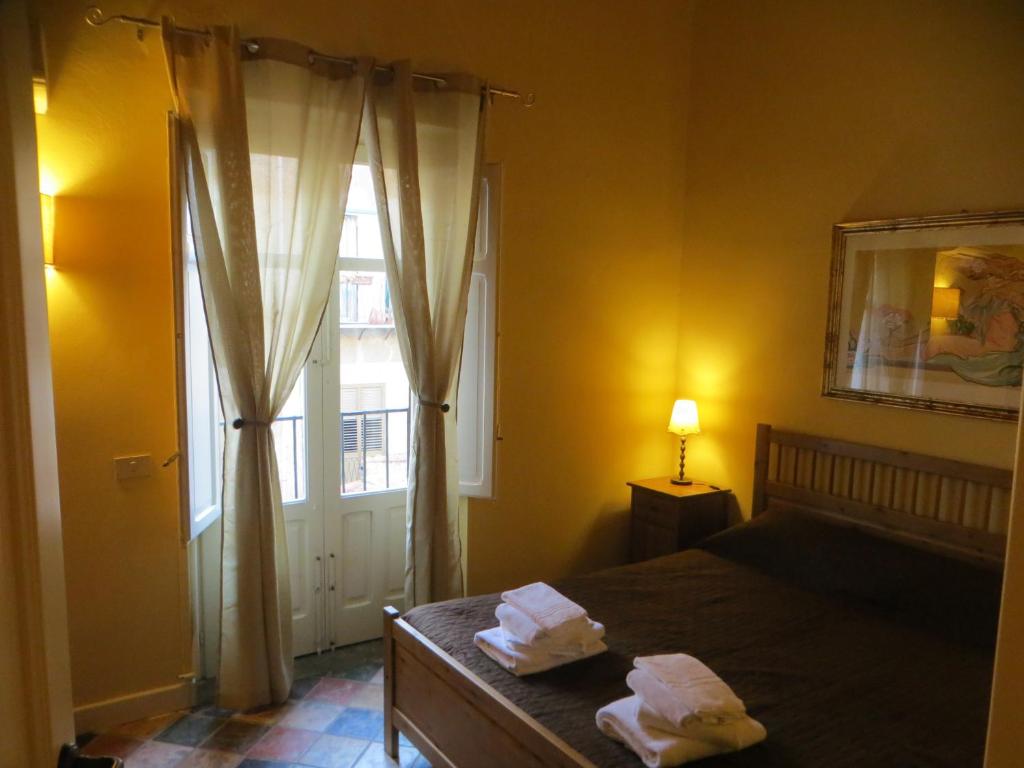 a bedroom with a bed and a window with towels at Junior Suite Cattedrale in Palermo