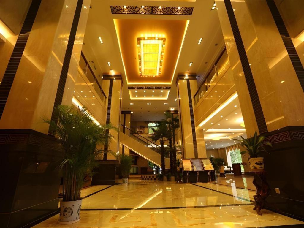 a lobby of a building with palm trees in it at Tong Da International Hotel in Zhangjiajie