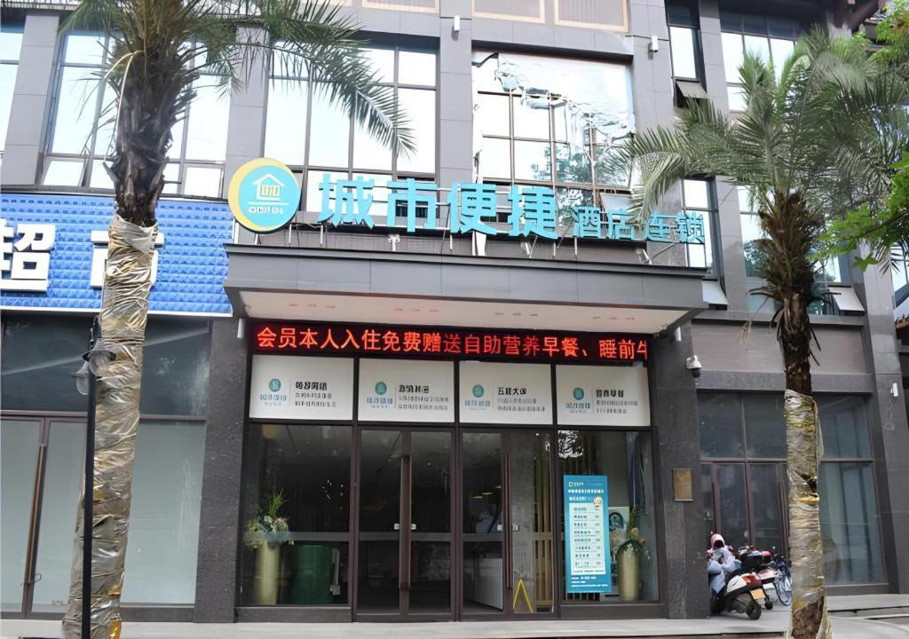 a building with palm trees in front of it at City Comfort Inn Meishan Sansu Temple in Meishan