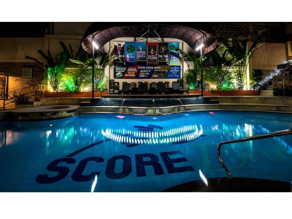 ein großer Pool mit einer Bar im Hintergrund in der Unterkunft Score Birds Hotel in Angeles
