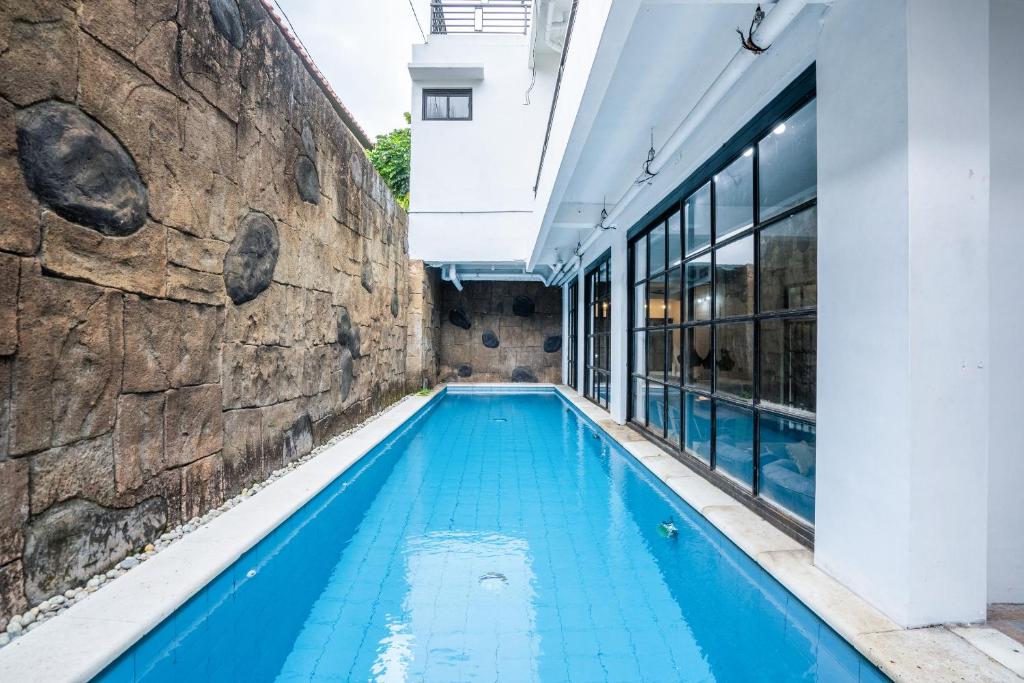 una piscina en un edificio con una pared de piedra en 5BR Villa Naga Sanur, en Sanur