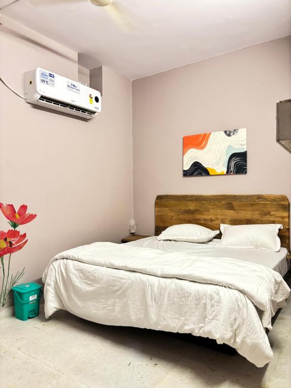 een slaapkamer met een bed en airconditioning aan de muur bij Hotel Downtown in Jodhpur