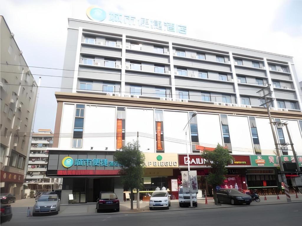 a large building with cars parked in front of it at City Comfort Inn Huizhou Economic College Shuikou Huxi Avenue in Huizhou