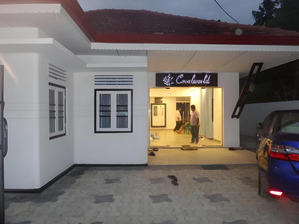 米瑞莎Coralworld Hotel的一对夫妇站在建筑物外面