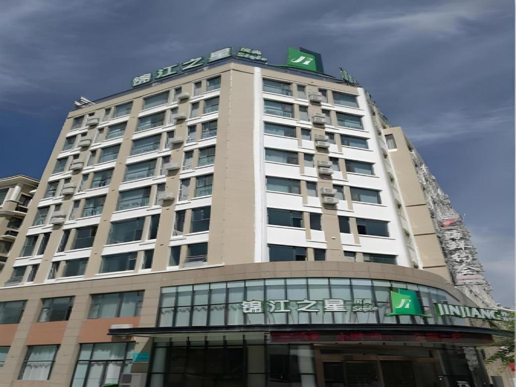 a tall building with a sign on top of it at Jinjiang Inn Style Ningxia Guyuan Beijing Road in Guyuan