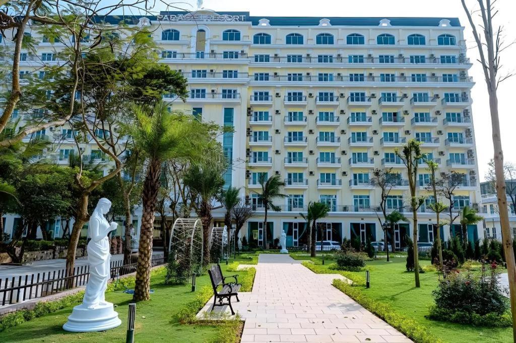 ein großes weißes Gebäude mit einer Statue davor in der Unterkunft Paracel Resort Hai Tien in Mỹ Ðuc