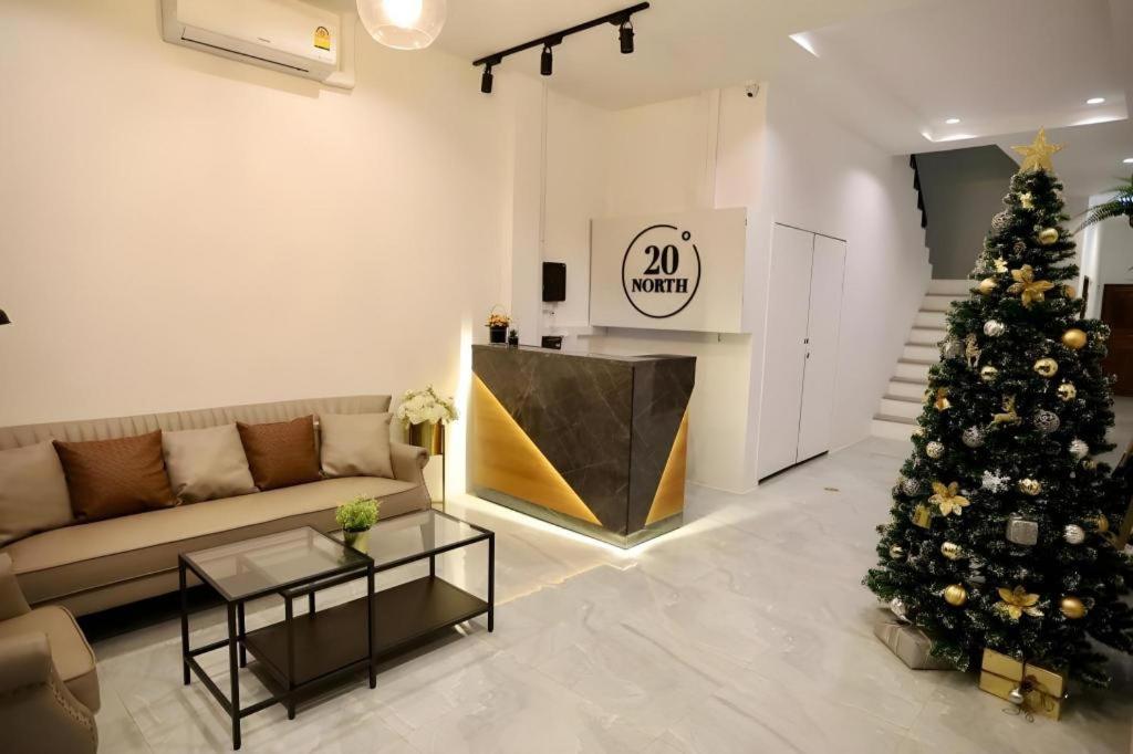 ein Wohnzimmer mit einem Weihnachtsbaum und einer Couch in der Unterkunft 20 North Hotel Mae Sai in Ban Pa Muat