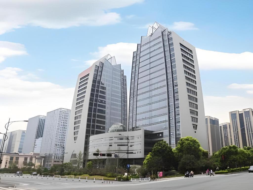 two tall buildings in front of a city at Hangzhou Huachen Fengting Hotel in Hangzhou