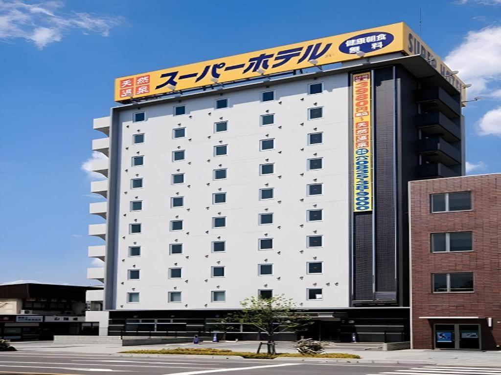 a large white building with a sign on it at Super Hotel Hofu-Ekimae in Yamaguchi
