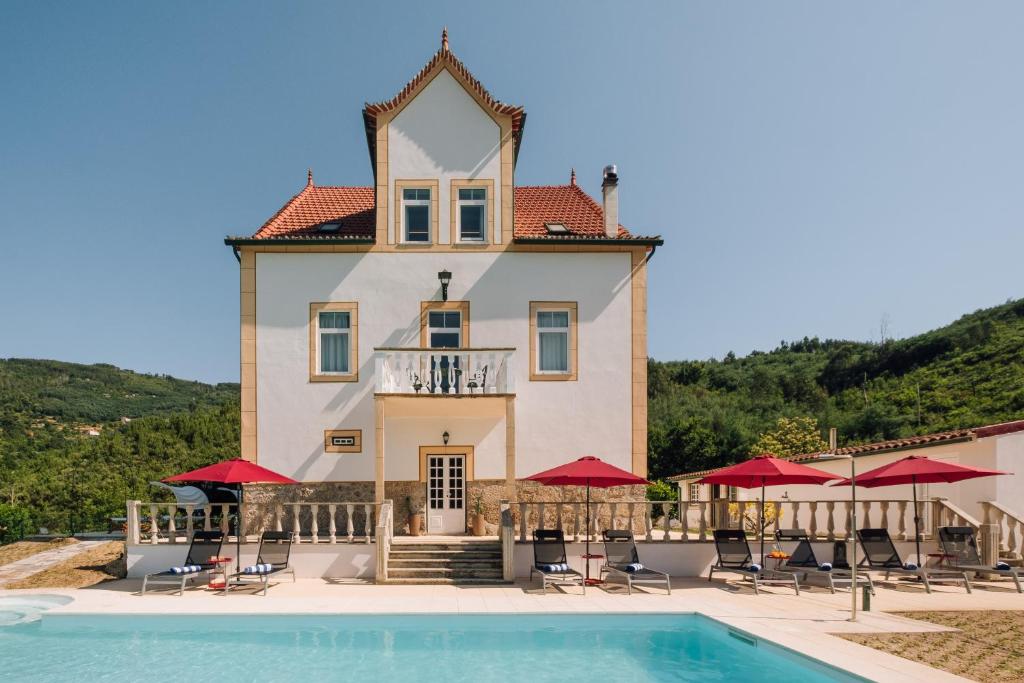 a large house with a pool in front of it at Palacete do Guerreiro SPA & Country House in Oliveira do Hospital